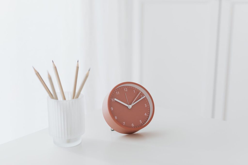 clock and pencils on desk